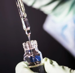 Scientist hand holding glass dropper with fluid